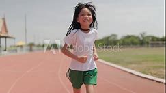 Portrait Thai Asian kid girls aged 8 to 10 years, looking cute in exercise clothes. Being at the starting point To start jogging in the red treadmill stadium Running gives her a healthy body.