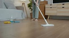 une femme fait des tâches ménagères, utilise des outils de nettoyage pour faciliter le nettoyage du sol, une employée de maison essaie d'enlever la poussière sur le sol parce qu'elle est sale, maintient l'hygiène dans la maison