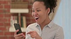 Portrait of African American Woman Celebrating on Smartphone