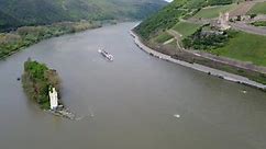 River cruise ship in middle Rhine valley amid Mouse tower and Ehrenfels Castle
