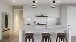Large white kitchen with island and massive wooden bar stools and all...