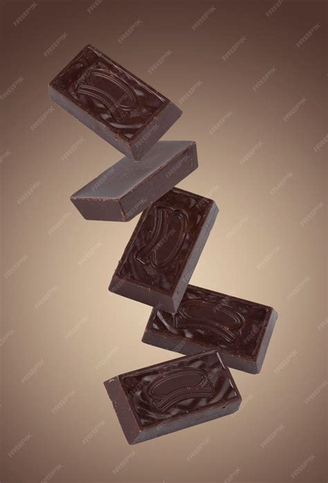 Premium Photo | Dark chocolate candies flying on a beige background mockup