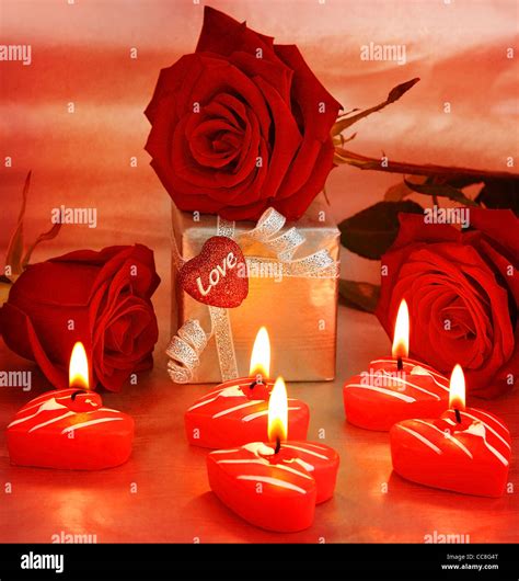 Romantic gift & red roses with candles, love concept Stock Photo - Alamy