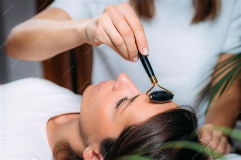 Premium Photo | Guasha face lymphatic drainage massage with jade stone roller