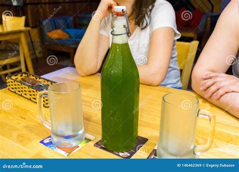 Big Bottle of Green Beer on Table in Cafe with Two Glasses Stock Image ...