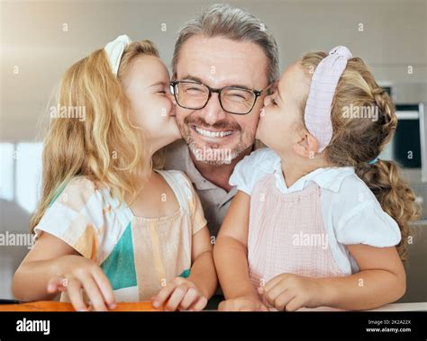 Young girls kiss father face, embracing them in their home. Portrait of ...