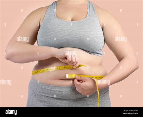 Overweight woman measuring her waist with a tape measure Stock Photo ...