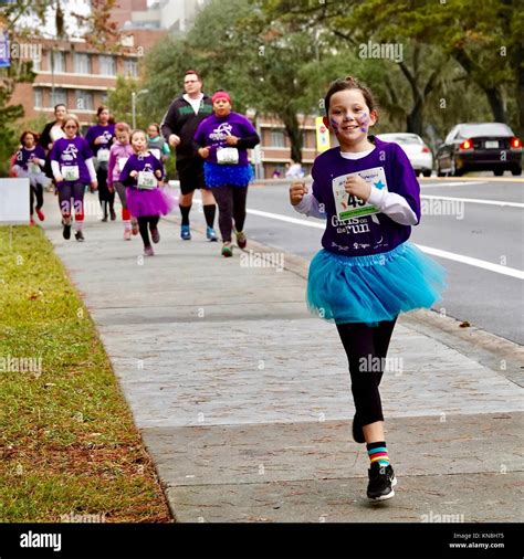 Young girl racing ahead of a group of runners in the Girls on the Run ...