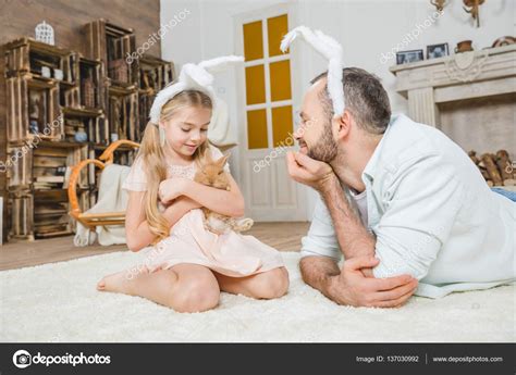Father and daughter playing with rabbit Stock Photo by ©AndreyBezuglov ...