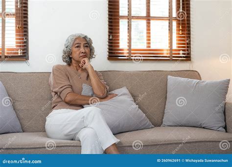 Thoughtful Mature Woman Sitting on Couch at Home Alone, Dreaming and ...