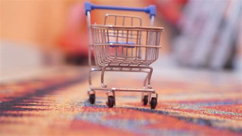 A miniature shopping cart sitting on top of a rug photo – Free Shopping ...