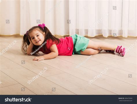 Happy Little Girl Lying On Floor Foto stock 380479909 | Shutterstock