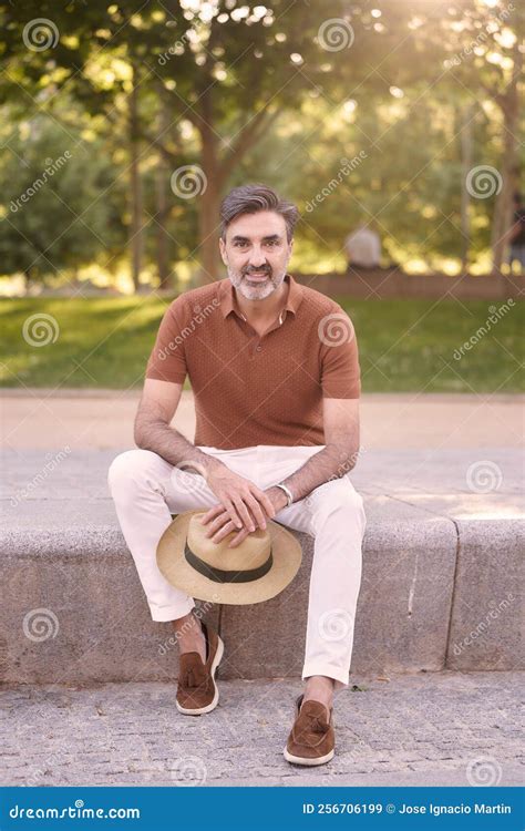 Relaxed Middle-aged Man Looking at Camera while Sitting on a Bench in a ...
