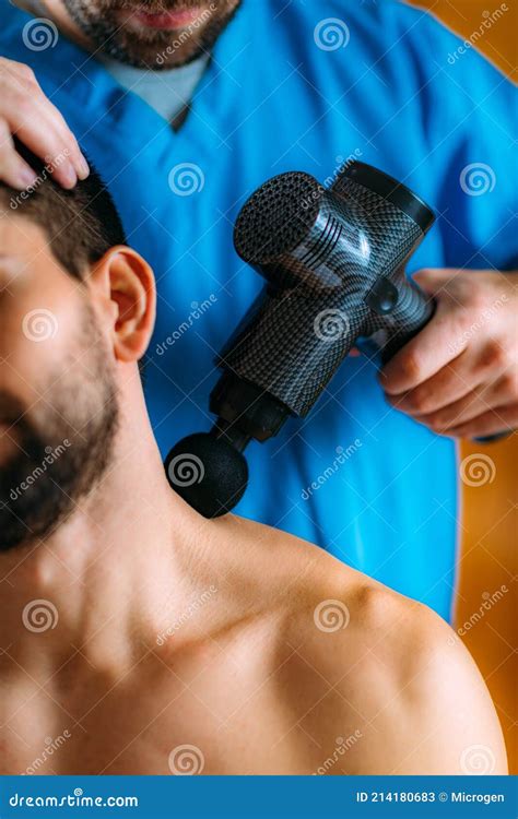 Therapist Treating Patient’s Trapezius Muscle with Massage Gun Stock ...