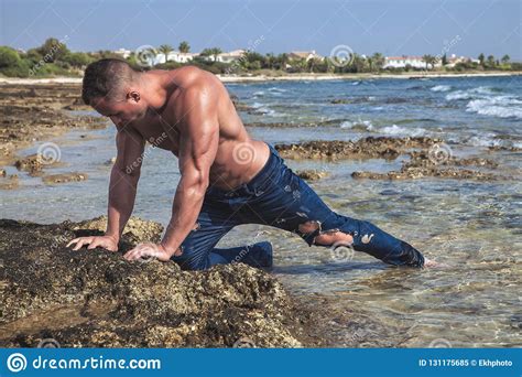 Muscular Young Wet Naked Athletic Guy Posing On The Beach In Blue Jeans ...