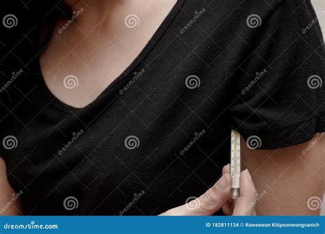 The Woman Measures the Temperature by Holding Thermometer Under Her Armpit. Concept of Health ...