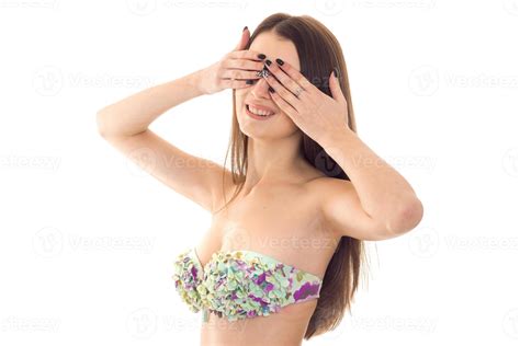 a young girl in a bathing suit with beautiful breasts closed her eyes with hands isolated on ...