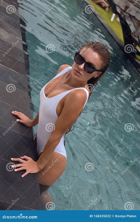 Beautiful Young Girl in a White Bathing Suit in the Pool Stock Photo ...