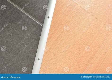 Joint of Floor Tiles and Laminate with a Dividing Strip, Closeup Stock ...