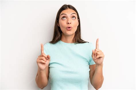 Feeling awed and open mouthed pointing upwards with a shocked and ...