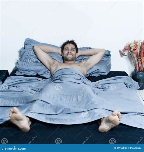 Handsome man in a bed stock image. Image of camera, head - 34962047