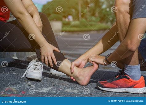 Young Man Massaging Young Woman on Painful Ankle. Suffering from Ankle ...