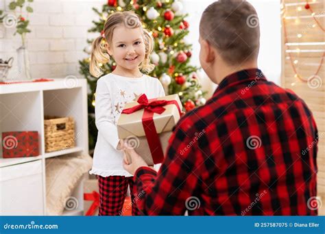 Father Giving a Present To His Happy Daughter Near Christmas Tree Stock ...