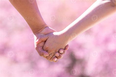 male and female couple holding hands to show friendship, love and ...