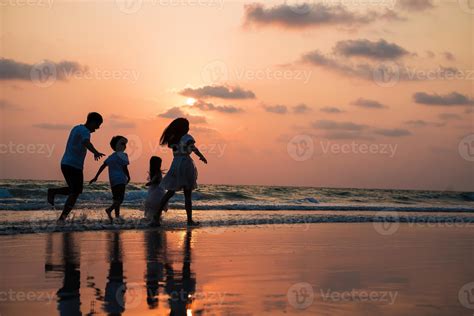 Silhouette family walking and playing at beach sunset with kids happy ...