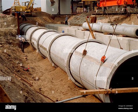 Pipe laying. Construction workers laying a pipeline Stock Photo - Alamy