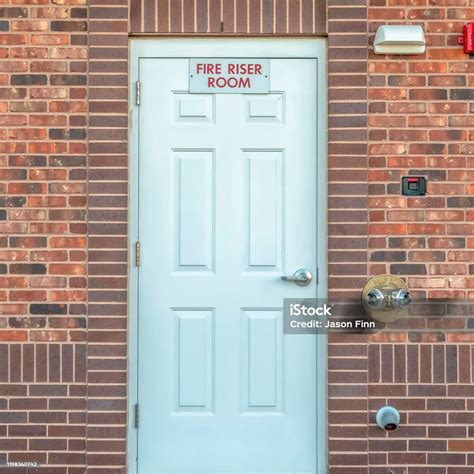 Square Fire Riser Room Sign On The White Wood Door Of A Building With ...