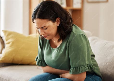 Premium Photo | Stomach pain stress and woman on a sofa with pms gas or ...