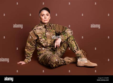 Full body photo of attractive mature woman army soldier sit floor ...