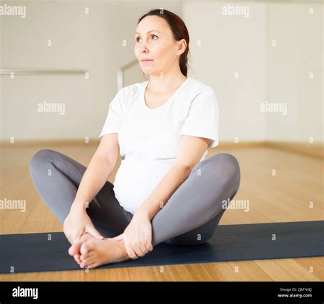 Pregnant woman is engaged in yoga. Butterfly Pose or Baddha Konasana ...