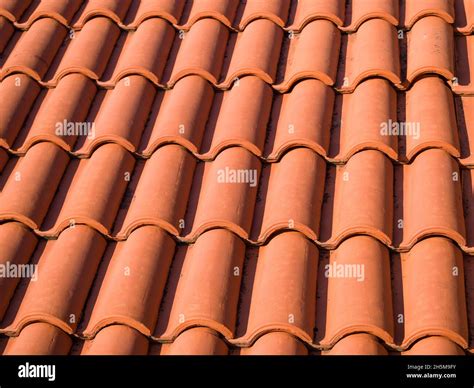 Closeup of the red clay roof tiles. Shingles. Old and used overlapping ...