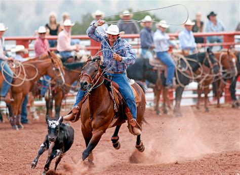 Download Cowboy riding a bucking bull at a rodeo event | Wallpapers.com