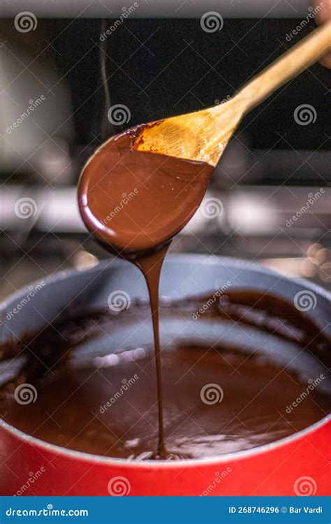Wooden Spoon Stirring Melting Dark Chocolate Over a Red Pan Stock Photo ...