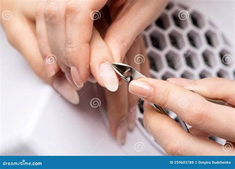 A Manicurist Removes Cuticles during a Nail Extension Procedure in a ...