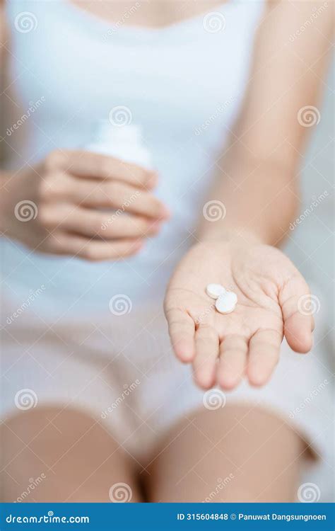 Woman Hand Holding Medicine Painkiller Pill on the Sofa at Home, Taking ...