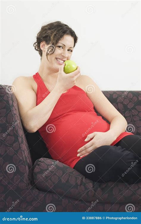 Pregnant Woman Eating Apple on Sofa Stock Photo - Image of healthy, happiness: 33887886