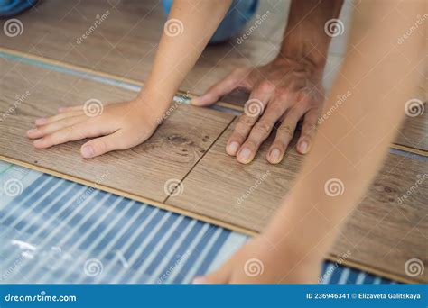 Father and Son Installing New Wooden Laminate Flooring on a Warm Film ...