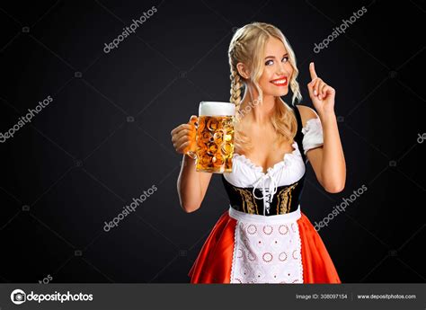 Smiling young sexy oktoberfest girl waitress, wearing a traditional ...