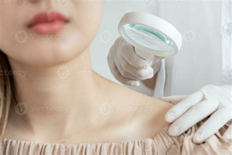skin problem and beauty of asian girl. specialist of skin use magnifying glass look itchy skin ...