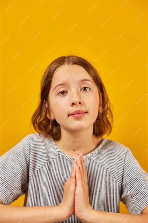 Premium Photo | Pleading teen girl on yellow studio background wish and ...