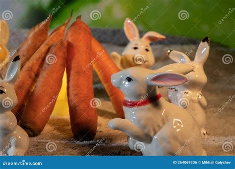 Porcelain Figurines of Rabbits Sit Around a Fire of Carrots. Stock ...