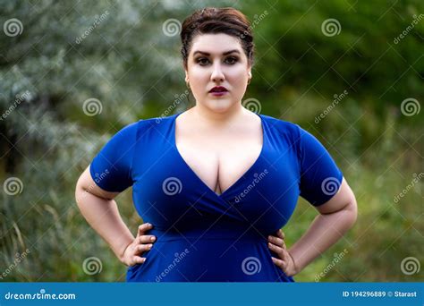 Plus Size Fashion Model in Blue Dress with a Deep Neckline Outdoors ...