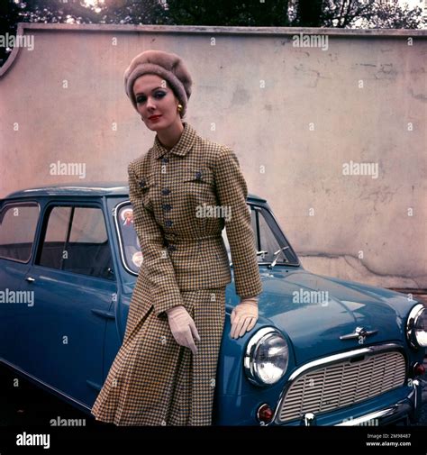 Woman in a tweed suit, hat and gloves, posing with a blue car Stock ...