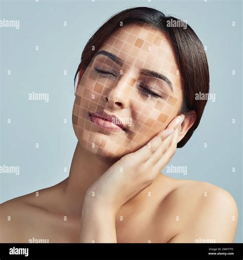 Its time to even that uneven skin tone. a young woman touching her face against a grey ...