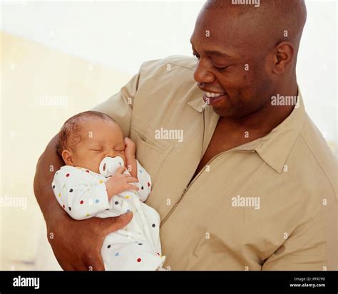 Man cradling baby hi-res stock photography and images - Alamy