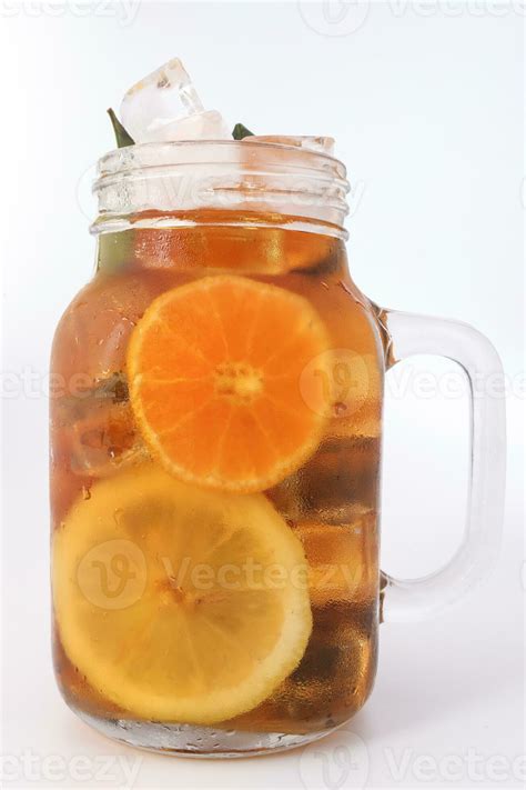 Liquid ice lemon orange tea with slice green leaf cinnamon stick in ...